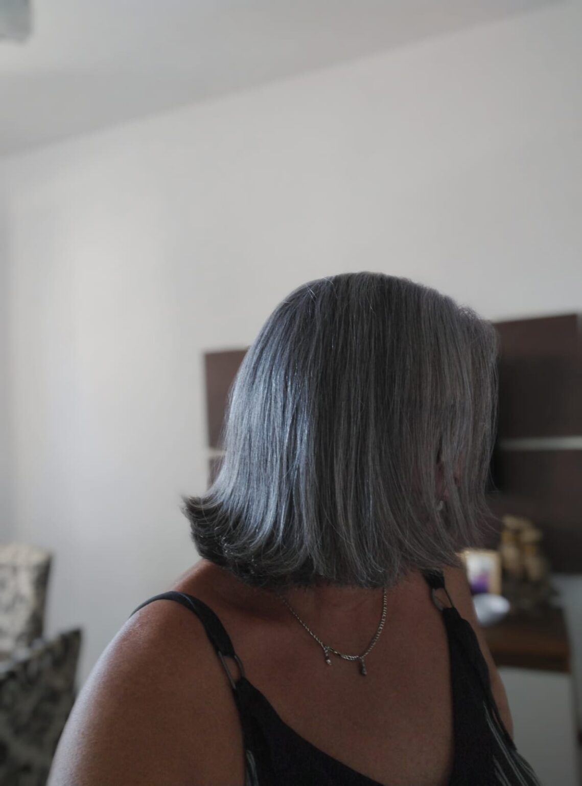 Cliente sorrindo segurando o frasco da Progressiva Vegetal